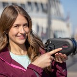 Eine Frau hält einen E-Bike-Antrieb in der Hand und zeigt mit dem Finger auf das Logo des Herstellers Brose.