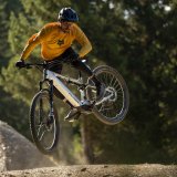 Ein Mann auf einem E-Mountainbike in der Luft.