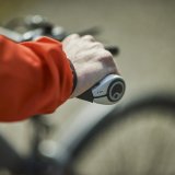 Die Hand einer Rad fahrenden Person am Fahrradlenker.