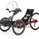 Ein Liegedreirad mit Handantrieb, einem großen Hinterrad und zwei kleineren Vorderrädern.