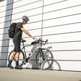 Ein Mann lehnt ein Fahrrad an eine Hauswand.