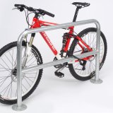 Ein Fahrrad lehnt an einem Anlehnbügel, der einem Stück Geländer ähnelt.