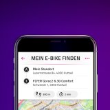 Ein Smartphone mit einer Kartenanwendung, die den Standort eines E-Bikes darstellt.