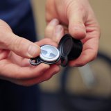 Eine Person öffnet eine Fahrradklingel, um ein Apple Airtag darin zu zeigen.