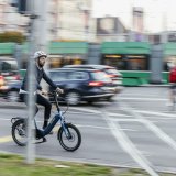 Ein Mann fährt auf einem Kompakt-Fahrrad durch die Stadt.