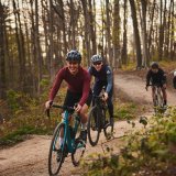 Ein Gruppe Radfahrender auf einem Waldweg.