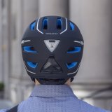 Rückansicht eines Fahrradhelmes auf dem Kopf einer Person.