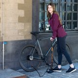 Frau pumpt Fahrradreifen auf