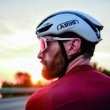 Ein Mann mit weißem Rennradhelm und Sportbrille.
