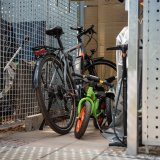 Fahrräder in einem Metallverschlag mit Tür.