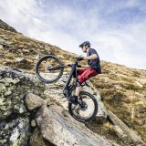 Mann fährt steile Rampen in den Bergen mit E-Mountainbike hoch