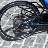 Das Hinterrad eines Liegerades auf Kopfsteinpflaster.