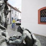 Mann fährt mit Fahrrad durch enge Gasse.