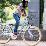 Ein Kind fährt im Stehen Fahrrad.