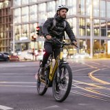 Ein Mann fährt auf einem E-Bike über eine Straßenkreuzung mit Straßenbahnschienen.