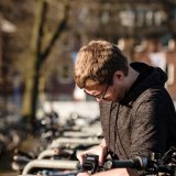 Ein Mann schließt ein E-Bike an einem Fahrradständer an.