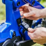 Eine Person schließt das Ladekabel an ein E-Bike an.