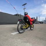 Eine Person fährt auf einem Liegerad in Richtung einer Großstadt-Skyline.