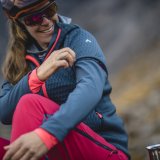 Eine Radfahrerin zeigt das Firmenlogo von Vaude auf dem Ärmel ihrer Jacke.