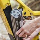 Detailaufnahme davon, wie ein integrierter Akku aus dem Rahmen eines E-Bikes entnommen wird.