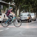 Ein Junge überquert auf einem Fahrrad eine Kreuzung.