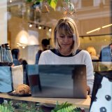 Eine Frau sitzt an einem Laptop.