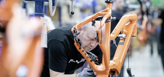 Ein Mann arbeitet an der Montage eines E-Bike-Rahmens.