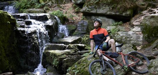 Mountainbiker vor Wasserfall
