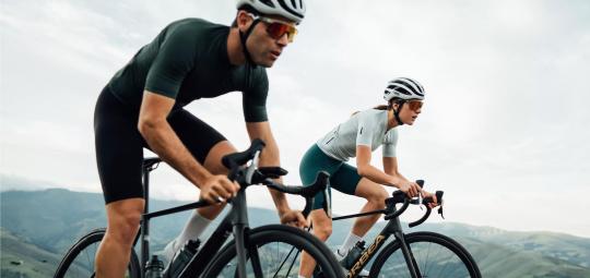 Zwei Personen fahren Rennrad in der Natur.