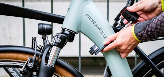 Die Rahmen zweier Fahrräder werden mit einem Faltschloss zusammengeschlossen.