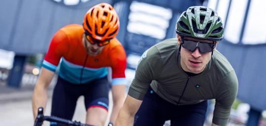 Zwei Rennradfahrer fahren auf den Betrachter zu.