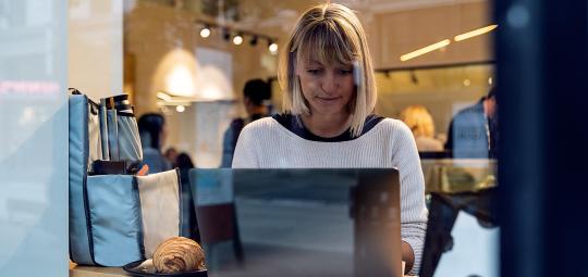 Eine Frau sitzt an einem Laptop.