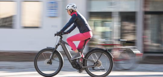Eine Person fährt auf einem E-Bike durch die Innenstadt.