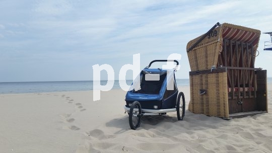 Ein Kinderanhänger hat Platz für diverse Strandutensilien.