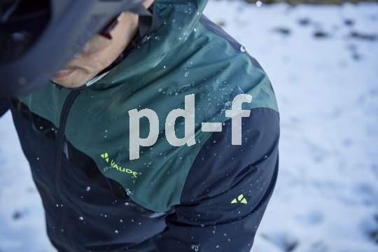 Abperlende Wassertropfen auf der Schulterpartie einer Jacke eines Radfahrers.