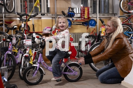 Sitzprobe auf dem ersten Fahrrad: der Sattel sollte niedrig genug sein, damit das Kind locker mit den Füßen auf den Boden kommt. Bei den ersten wackeligen Fahrversuchen sorgt das für Sicherheit.
