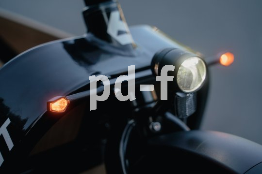 Frontscheinwerfer eines Lastenrades mit zwei kleinen orangenen Lichtern an den Seiten.