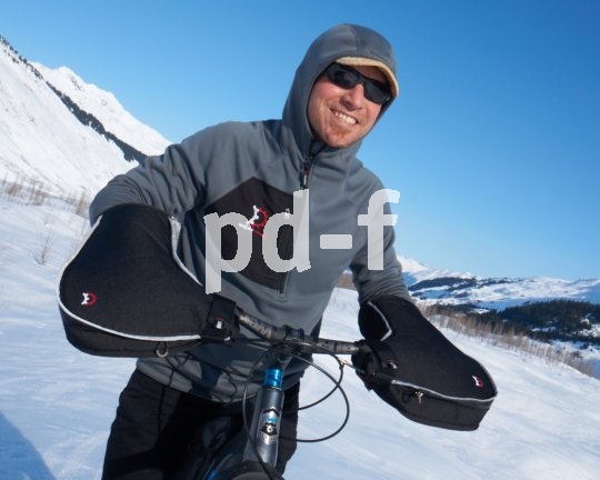 Die "Williwaw-Pogies" von Hersteller Revelate Designs sind keine klassischen Handschuhe, sonder lenkerfeste Handwärmer, in die man beim Losfahren hineinschlüpft. Sehr praktisch und warm. Sind sie zu warm, lassen sich vorn kleine Belüftungsreißverschlüsse öffnen.