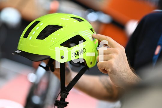 Eine Person präsentiert einen Fahrradhelm in Neongelb.