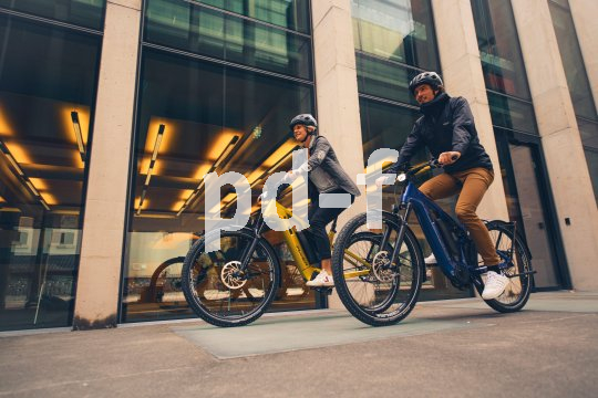 Paar fährt auf Fahrrädern nebeneinander durch die Stadt.