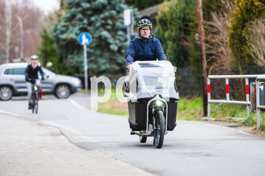 Mann fährt mit Cargobike auf Radweg