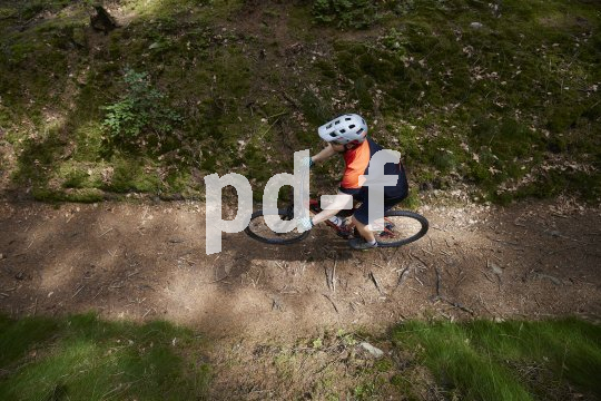 Mountainbiker auf Waldweg von oben.