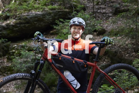 Mountainbiker mit Fahrrad im Wald