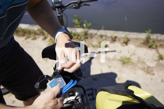 Eine Person hantiert an einer Satteltasche eines Fahrrades herum.