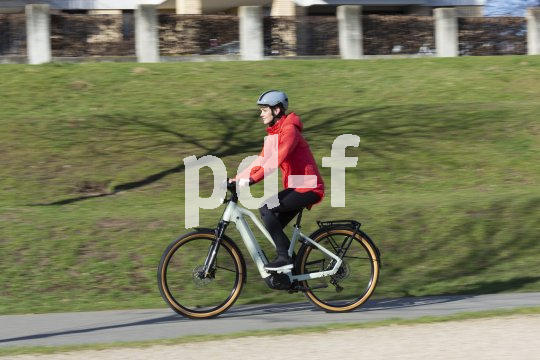 FRau fährt mit E-Bike im Frühling