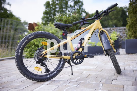 Kinder-Mountainbikes können mit nur wenigen Handgriffen zu sicheren Schulwegbegleitern umgebaut werden. Kinder-Mountainbike steht in Einfahrt.