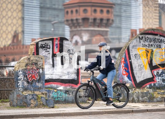 E-Bikes ermöglichen gerade in der Stadt eine schnelle Fahrt von A nach B. Frau fährt mit E-Bike durch Berlin