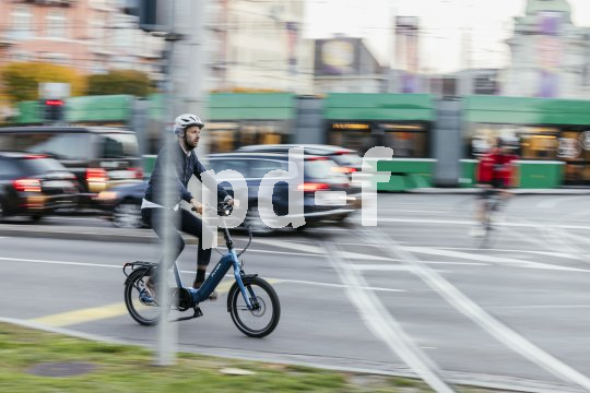 Eine aufrechte Sitzposition hilft, im Trubel des Stadtverkehrs den Überblick zu bewahren. Ein Mann fährt auf einem Kompakt-Fahrrad durch die Stadt.