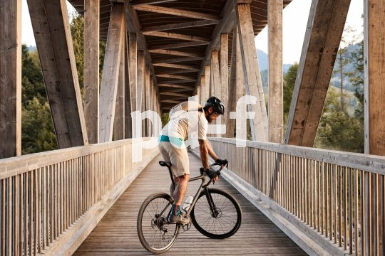 Gravelbikes ermöglichen Rennrad-Fans neu Wege. Mann mit Gravelbike auf Brücke