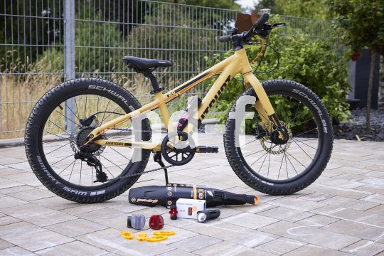 Kinder-MTB steht in Einfahrt mit Zubehör